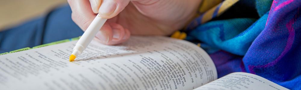 person highlighting a Bible